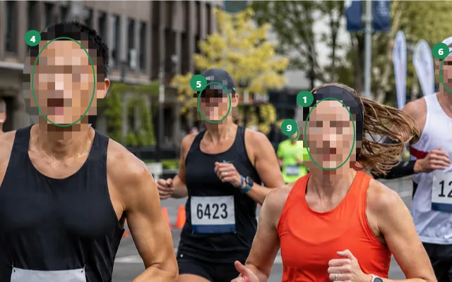 Close-up of the Occlira photo screen: runners in a marathon photo with their faces detected, numbered and pixelated so they cannot be recognised.